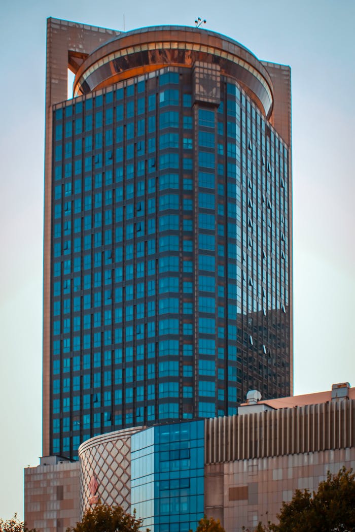 Tall modern building with glass facade under clear blue sky.