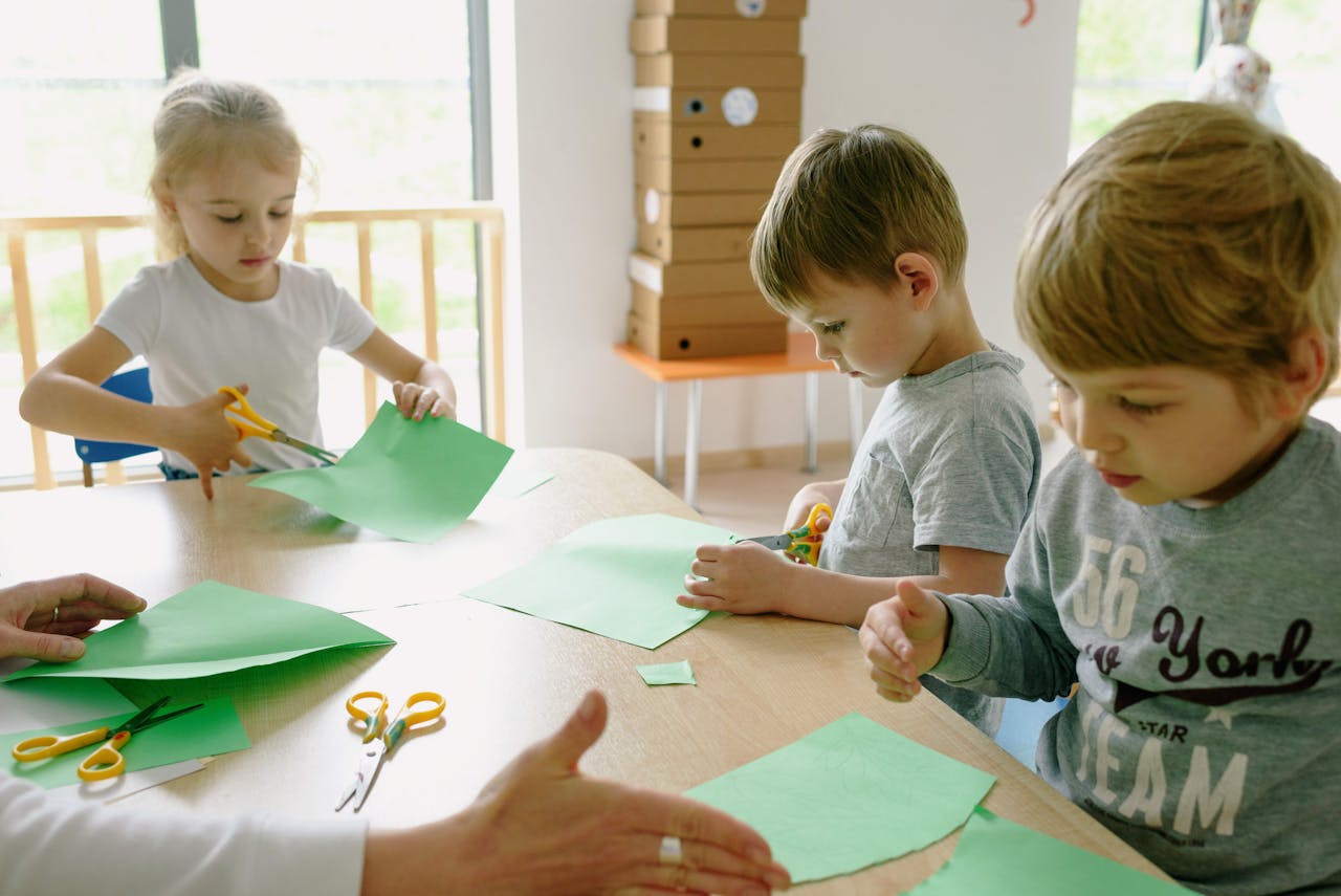 Group of children crafting with scissors and paper in a classroom setting, fostering creativity.